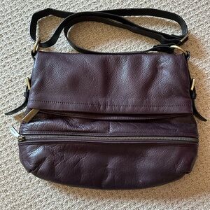 Dark purple Danier leather cross body bag with a black strap and gold hardware